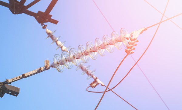 High-voltage electrical insulator electric line against the dark blue sky